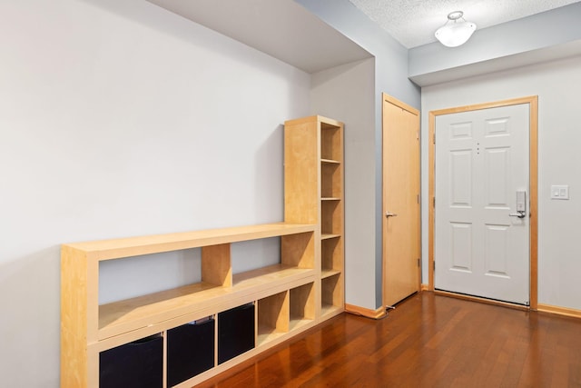 entrance foyer featuring baseboards, a textured ceiling, and wood finished floors