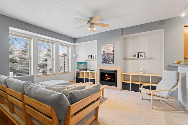 bedroom featuring baseboards, a tile fireplace, a textured ceiling, and carpet