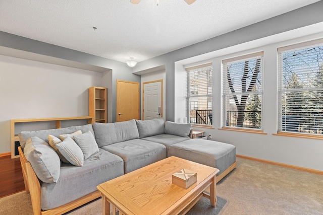 living room with baseboards, a textured ceiling, and light carpet