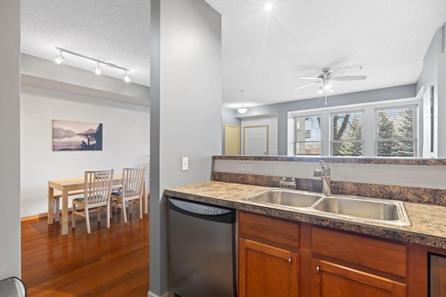 kitchen featuring dark wood finished floors, ceiling fan, a sink, a textured ceiling, and stainless steel dishwasher