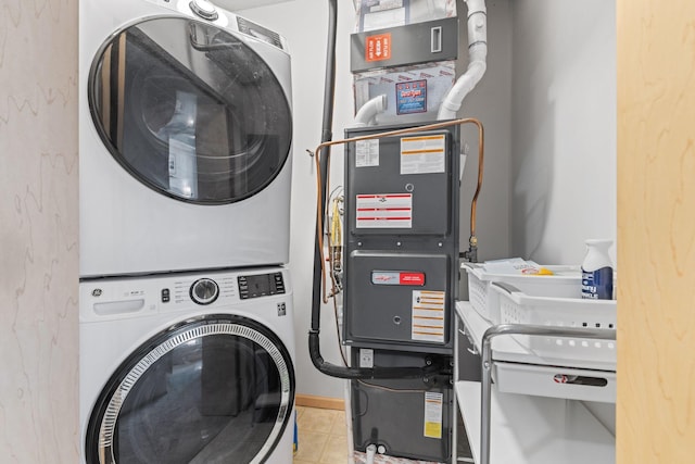 laundry area with tile patterned flooring, laundry area, and stacked washer and dryer