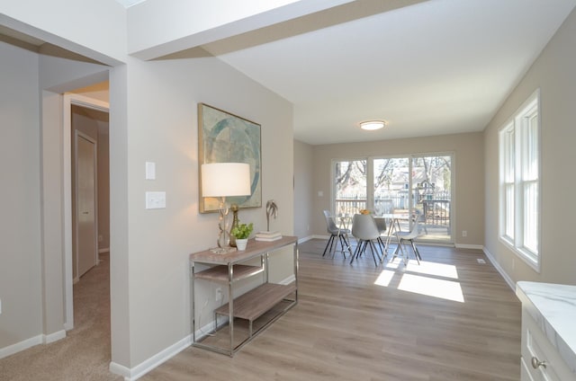 hallway featuring baseboards and light wood finished floors