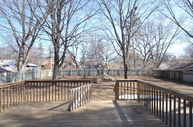 deck with a residential view, a fenced backyard, and a playground