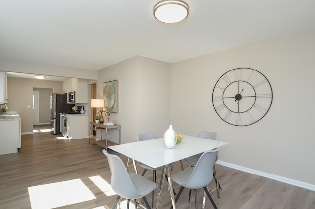 dining area featuring baseboards and wood finished floors