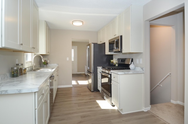 kitchen featuring a sink, light countertops, white cabinets, and stainless steel appliances