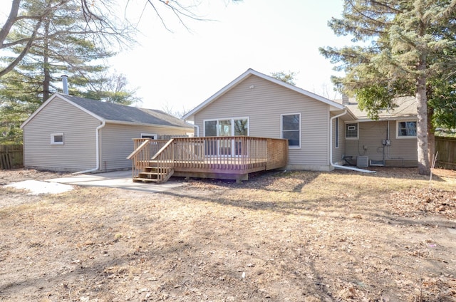 rear view of property with a wooden deck and fence