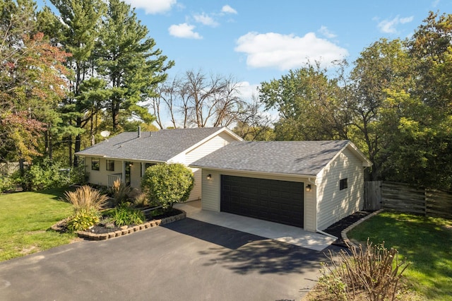 single story home featuring fence, roof with shingles, an attached garage, a front lawn, and aphalt driveway