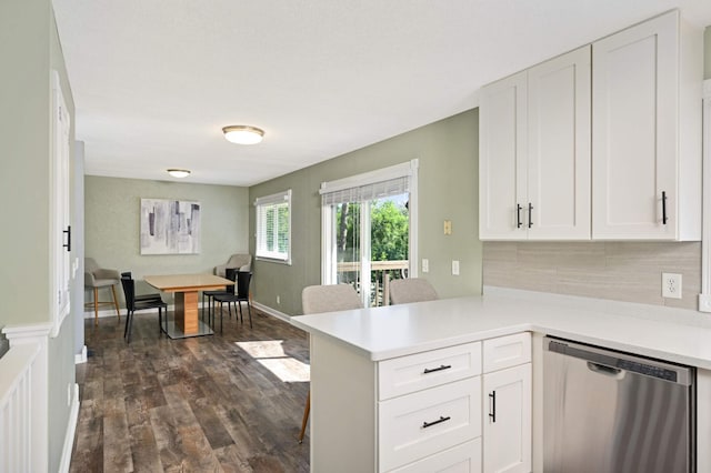 kitchen featuring dishwasher, light countertops, a peninsula, and white cabinetry