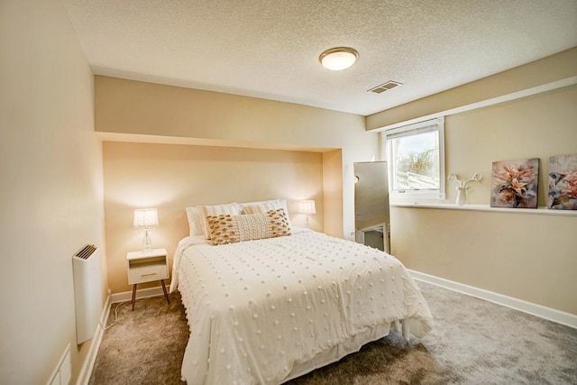 bedroom featuring visible vents, a textured ceiling, radiator heating unit, carpet, and baseboards