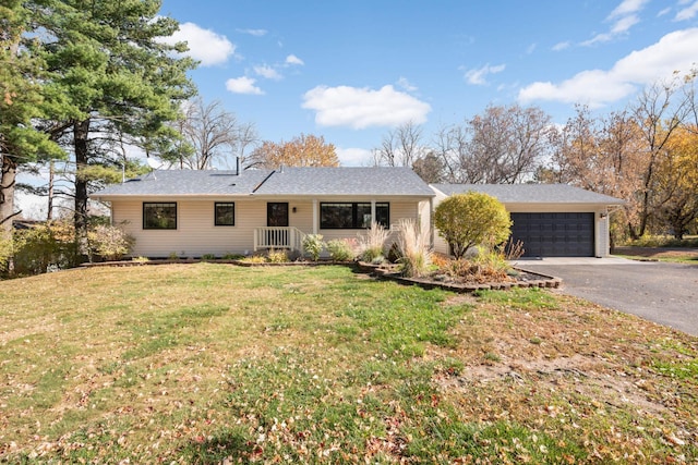 single story home with aphalt driveway, a front lawn, and an attached garage