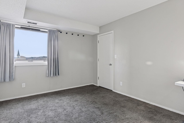 carpeted empty room with visible vents and baseboards