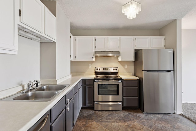 kitchen featuring under cabinet range hood, light countertops, appliances with stainless steel finishes, white cabinets, and a sink