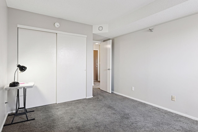 unfurnished bedroom with a closet, baseboards, and carpet