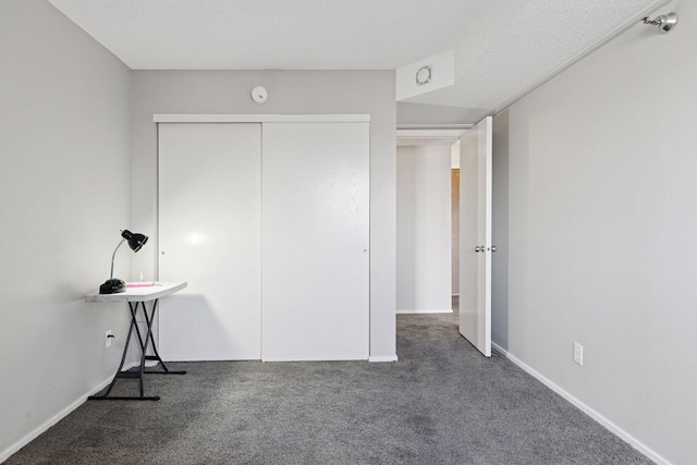 unfurnished bedroom with a closet, baseboards, and carpet flooring