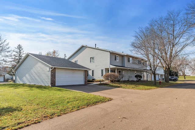 view of front of property featuring a front lawn, a garage, brick siding, and aphalt driveway