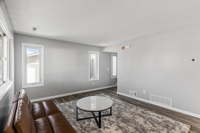 living area with visible vents and dark wood-style flooring