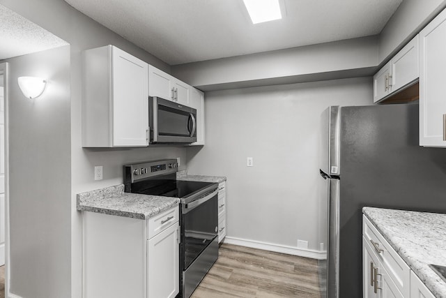 kitchen featuring white cabinets, light wood-style floors, and stainless steel appliances