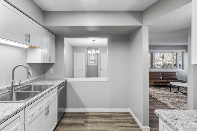 kitchen with baseboards, dark wood finished floors, dishwasher, white cabinetry, and a sink