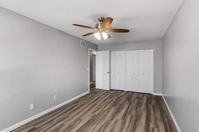 unfurnished bedroom featuring wood finished floors, baseboards, and visible vents