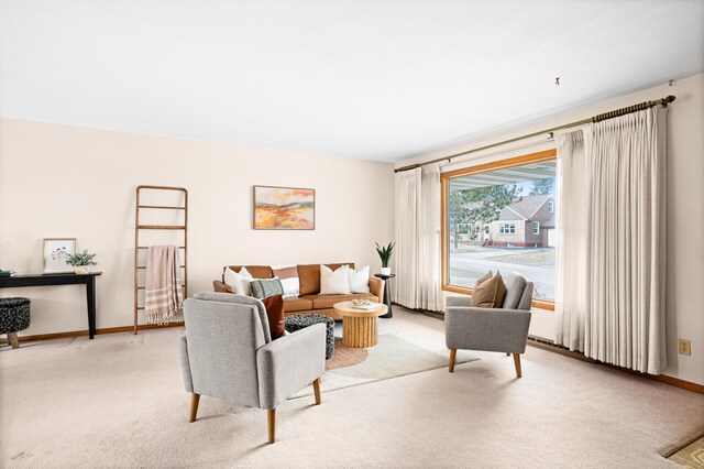 living room featuring light carpet and baseboards
