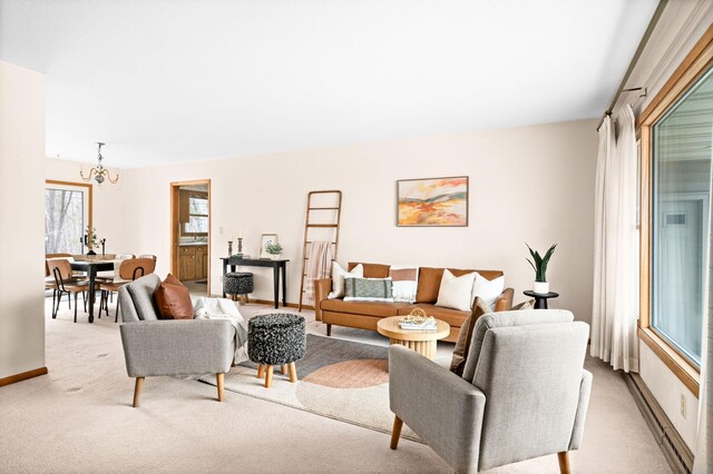 carpeted living room with baseboards and a notable chandelier