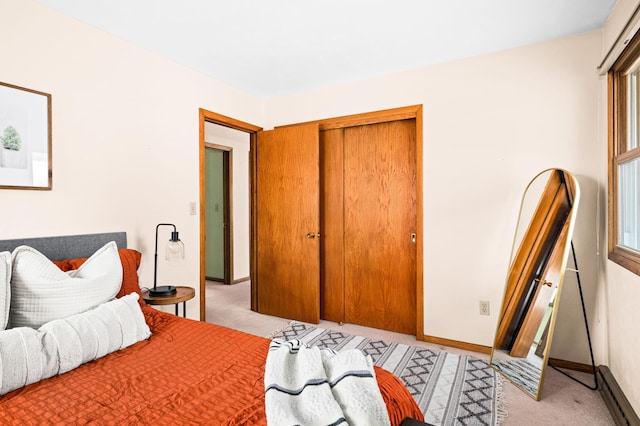 bedroom with light carpet, baseboards, and a closet