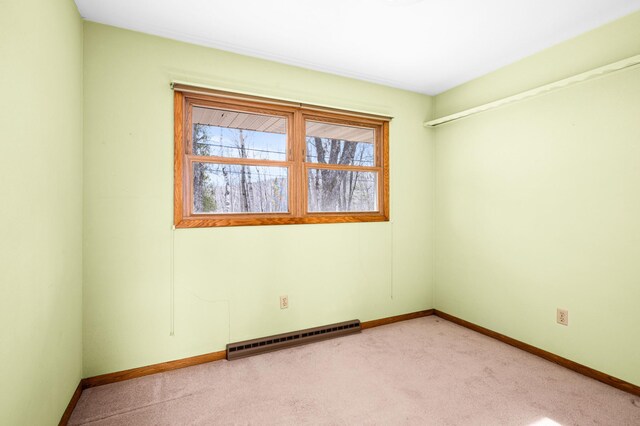 unfurnished room with baseboards, light colored carpet, a wealth of natural light, and a baseboard radiator