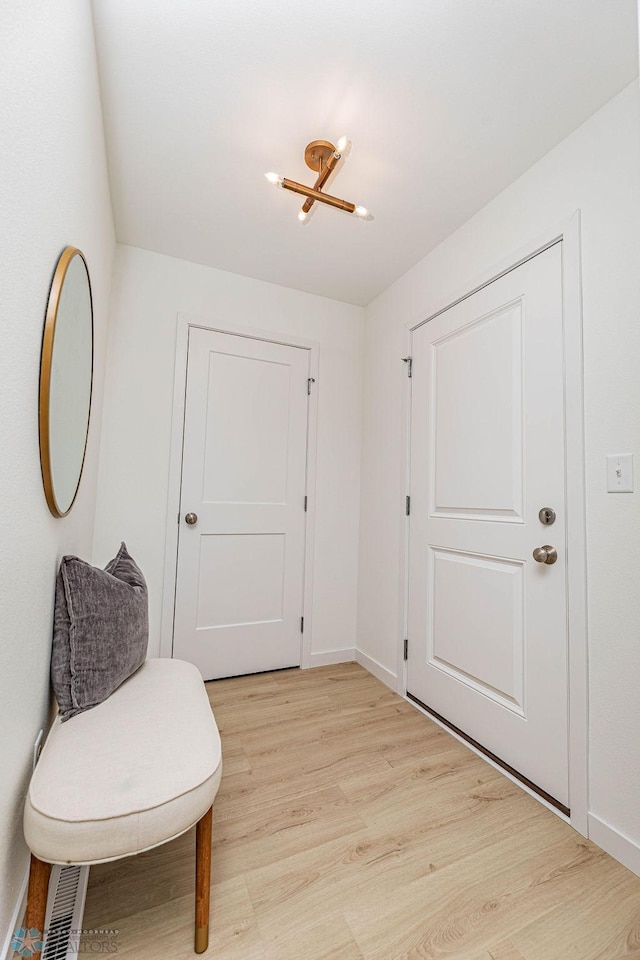 sitting room with baseboards and light wood finished floors