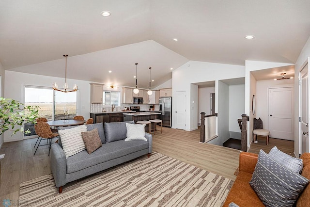 living area featuring a chandelier, recessed lighting, light wood-style flooring, and lofted ceiling