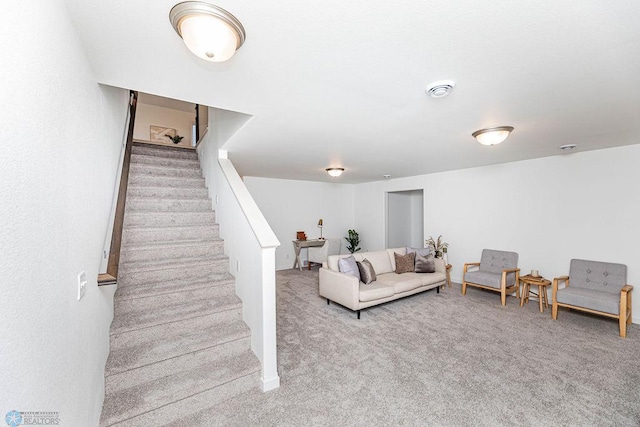 carpeted living area with stairway