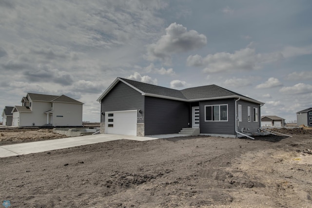 single story home featuring concrete driveway, entry steps, and a garage