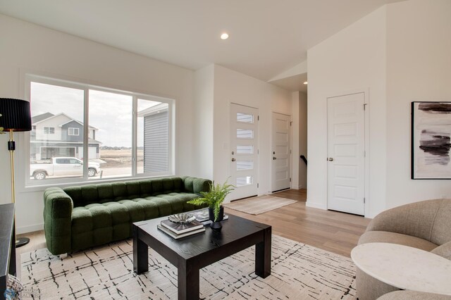 living area with recessed lighting, baseboards, and light wood finished floors