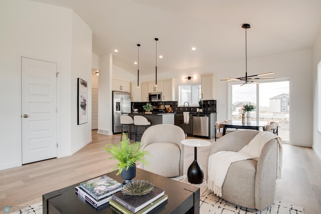 living room with recessed lighting, baseboards, a notable chandelier, and light wood finished floors