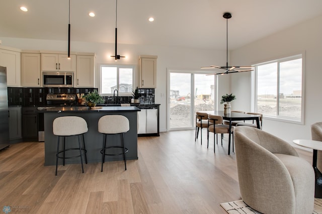 kitchen with a kitchen island, stainless steel appliances, a wealth of natural light, and backsplash