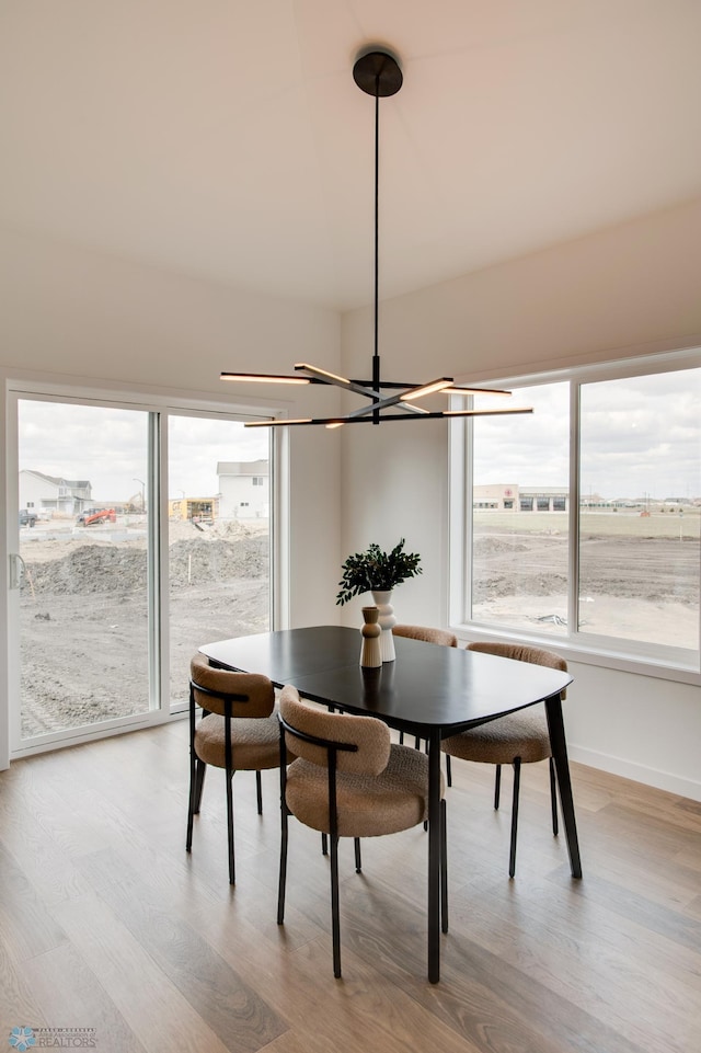 dining area with light wood-style floors, a chandelier, and a wealth of natural light