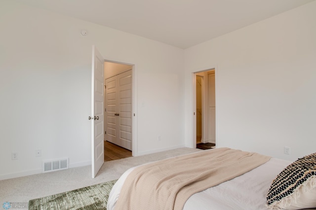 carpeted bedroom with visible vents and baseboards