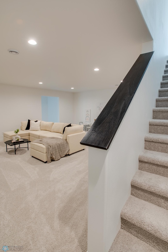 carpeted living area with stairway and recessed lighting