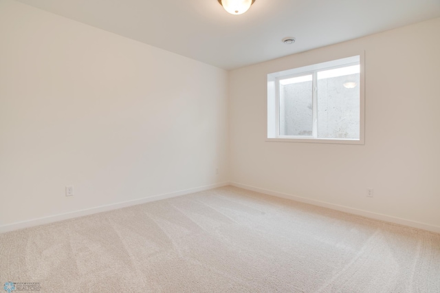 empty room with baseboards and light carpet