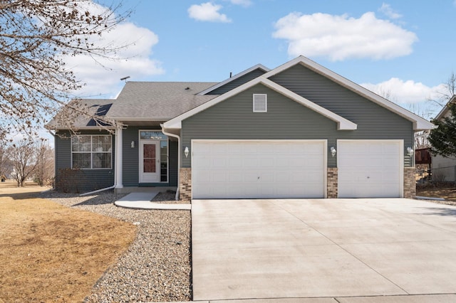 view of front of home featuring stone siding, an attached garage, and concrete driveway