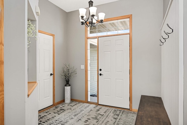 entrance foyer featuring baseboards and a chandelier