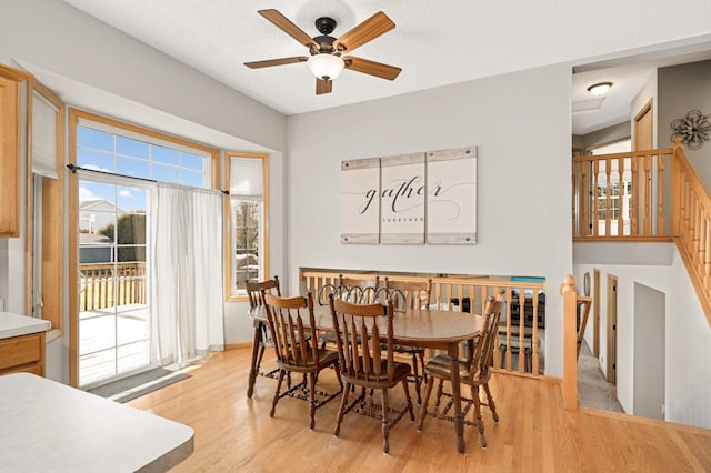 dining space with ceiling fan, a textured ceiling, and light wood-style floors