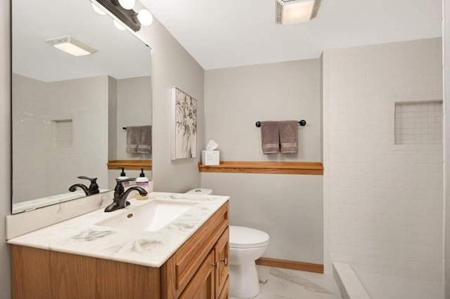 full bath featuring vanity, baseboards, tiled shower, toilet, and marble finish floor