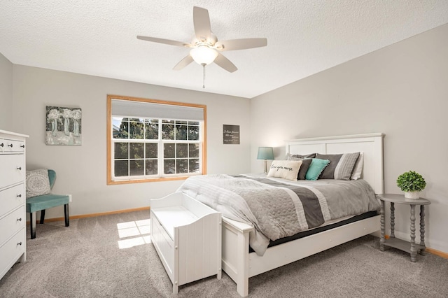 bedroom with baseboards, light colored carpet, a ceiling fan, and a textured ceiling