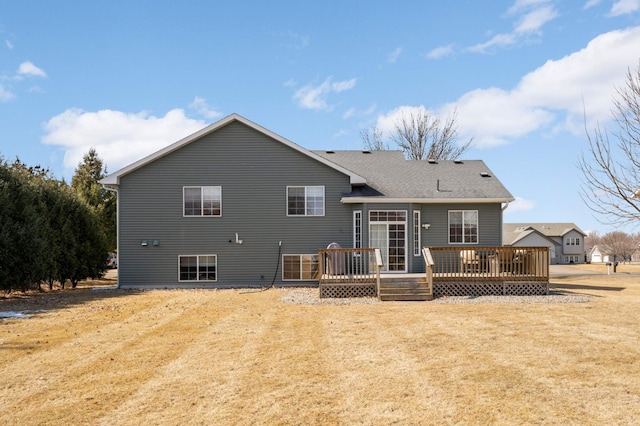 rear view of house with a wooden deck and a yard