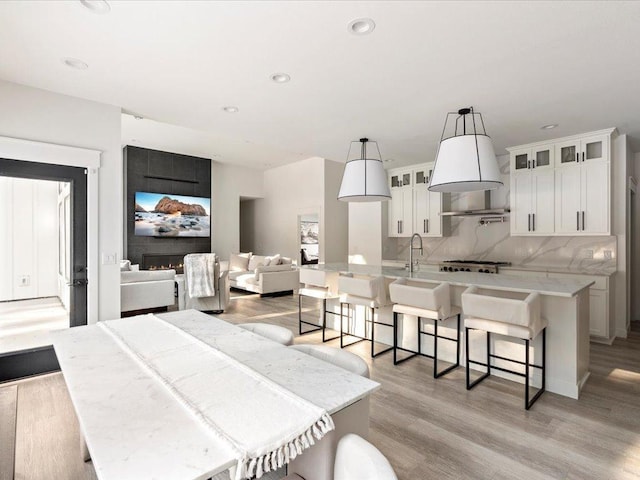 dining room with recessed lighting, light wood-style flooring, and a large fireplace