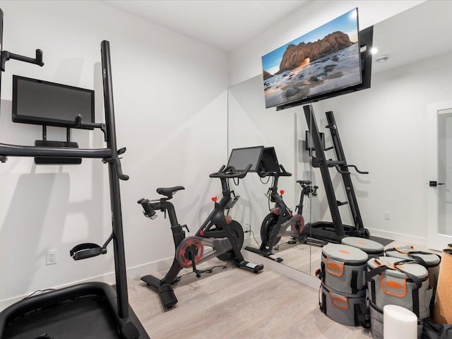 exercise area featuring baseboards and wood finished floors