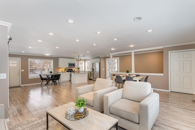 living area with recessed lighting, ornamental molding, and light wood finished floors