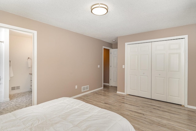 bedroom featuring visible vents, baseboards, light wood-style floors, and a closet