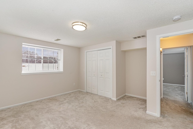 unfurnished bedroom with carpet flooring, baseboards, visible vents, and a closet