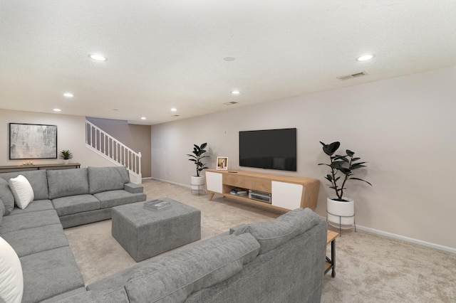 living room featuring light carpet, visible vents, stairway, and baseboards